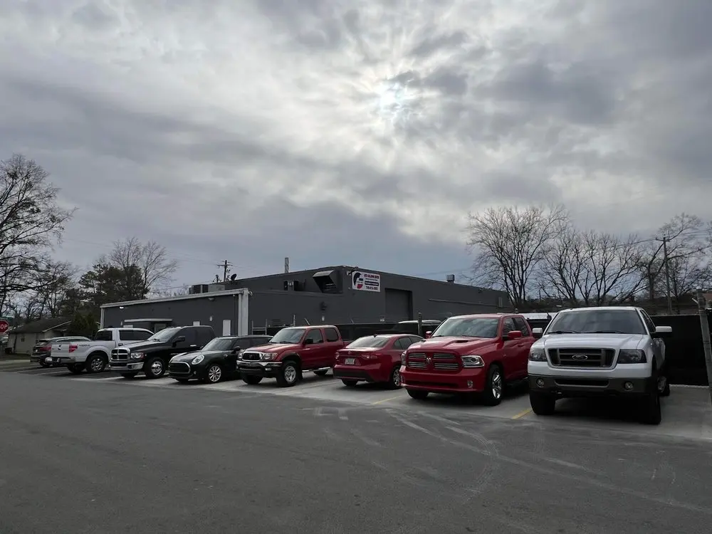 Trucks and cars parked outside Car-Aid's shop on Riverbend Drive in Dalton